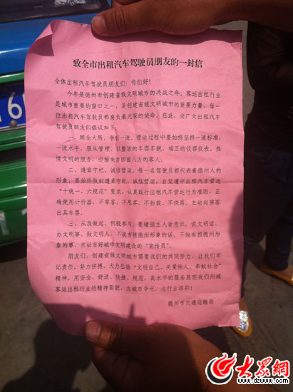 出租车司机向记者展示运管处发放的致司机朋友的一封信 记者 石少军